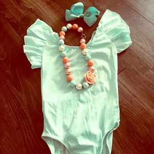 Turquoise/mint color body suite.